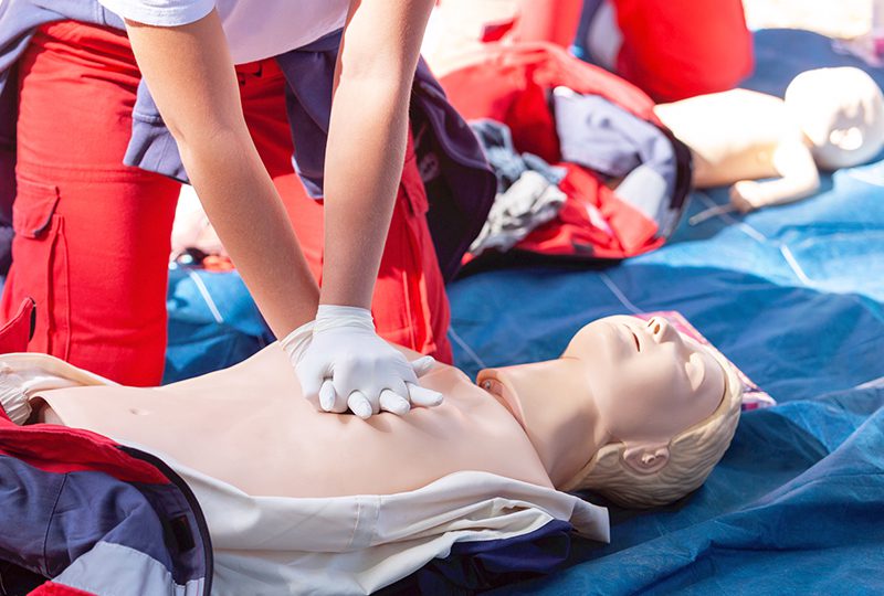 CPR training on a medical mannequin outdoors.