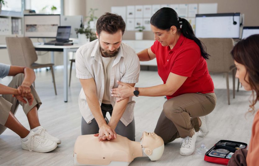 CPR training with instructor and mannequin.