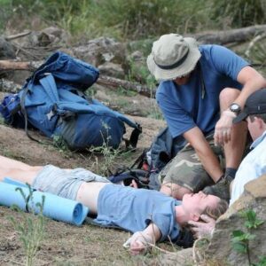 People attending to injured person outdoors.
