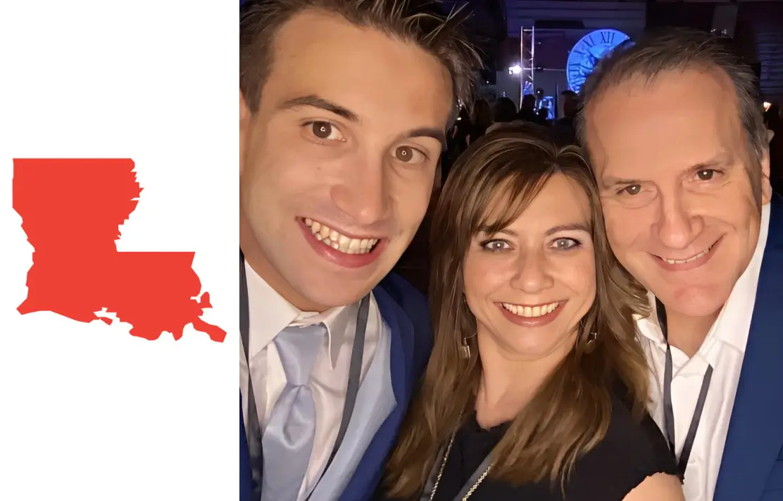 Three friends smiling together at a nighttime event.